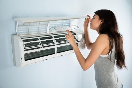 年轻女子检查空调过滤器